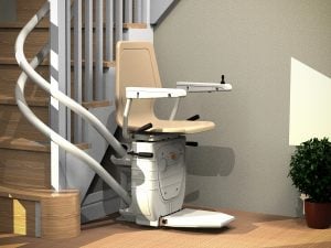 Curved beige stairlift at bottom of wooden stairs