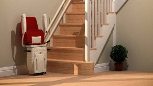 Red stairlift at bottom of wooden stairs