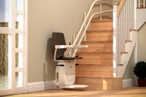 Brown stairlift at bottom of wooden stairs